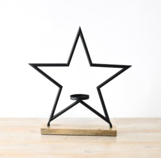 Black Star Candle Holder - Large, open star frame with tealight cup on wooden base, on white