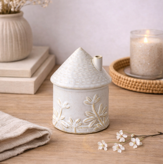 Ceramic House Ornament with Floral Detail, small white embossed house beside a candle
