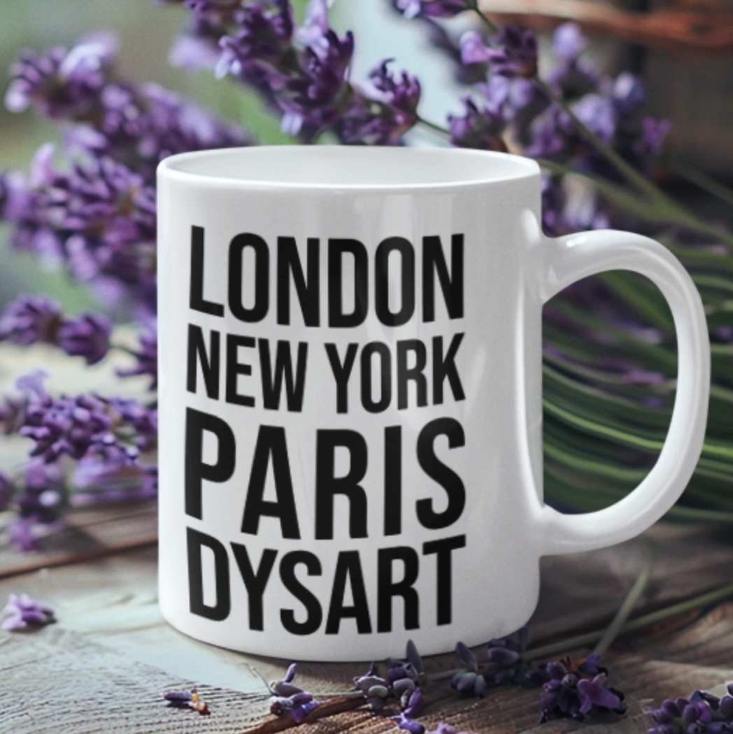Dysart Mug, a white mug with bold black London New York Paris Dysart lettering, among lavender sprigs