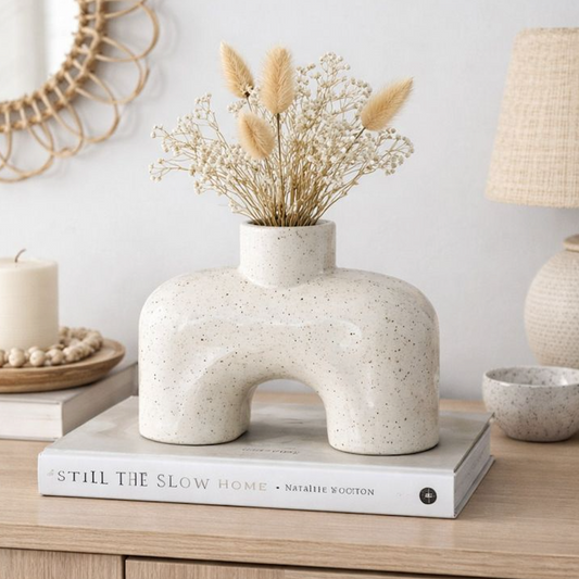 Earthenware Vase, textured cream arch vase with dried grasses on a stack of books