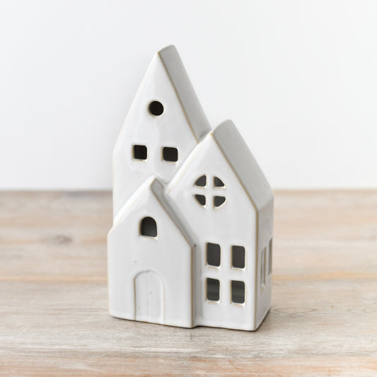 White Ceramic LED Christmas House Decoration on its own on a wooden surface, showing its gabled roofline