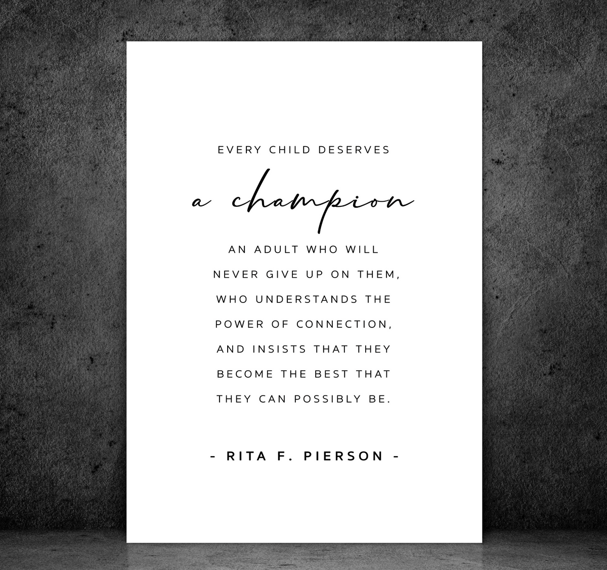 A Champion - Teacher print, the Rita F. Pierson quote on white, shown unframed against a dark concrete wall