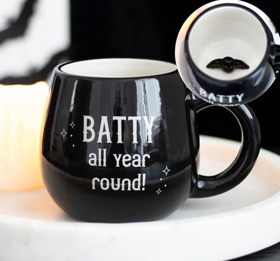 Batty All Year Round Mug in black with white lettering, shown with a bat silhouette inside the cup