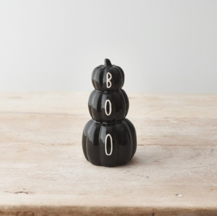 Black Pumpkin Stack of three black pumpkins with white BOO lettering, on a plain pale surface