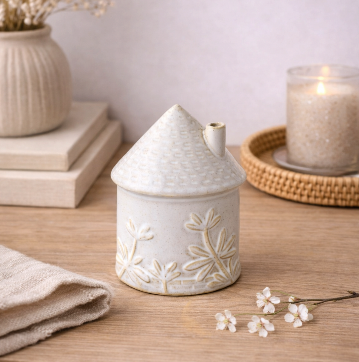 Ceramic House Ornament with Floral Detail, small white embossed house beside a candle