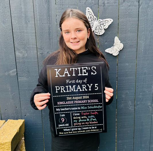 Chalkboard Personalised First Day School Print, a black chalkboard-style sign held by a smiling child