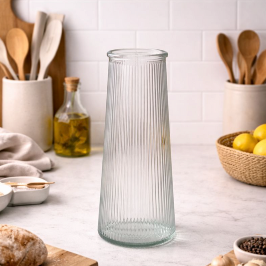 Clear Tall Ribbed Vase in glass on a kitchen worktop with utensils and a bowl of lemons behind