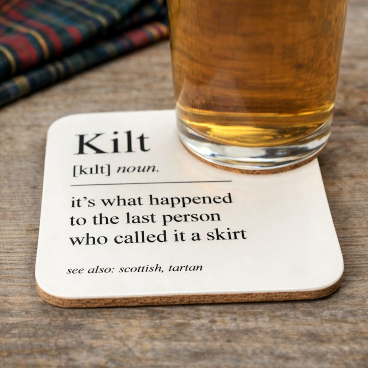 Funny Scottish Coaster, Kilt definition coaster under a pint glass on a tartan surface