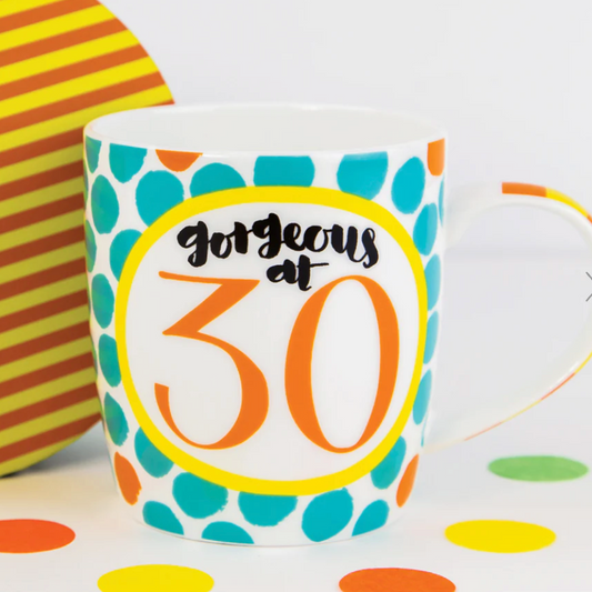 Gorgeous at 30 Mug, a white mug with teal spots and an orange 30 badge, beside striped packaging