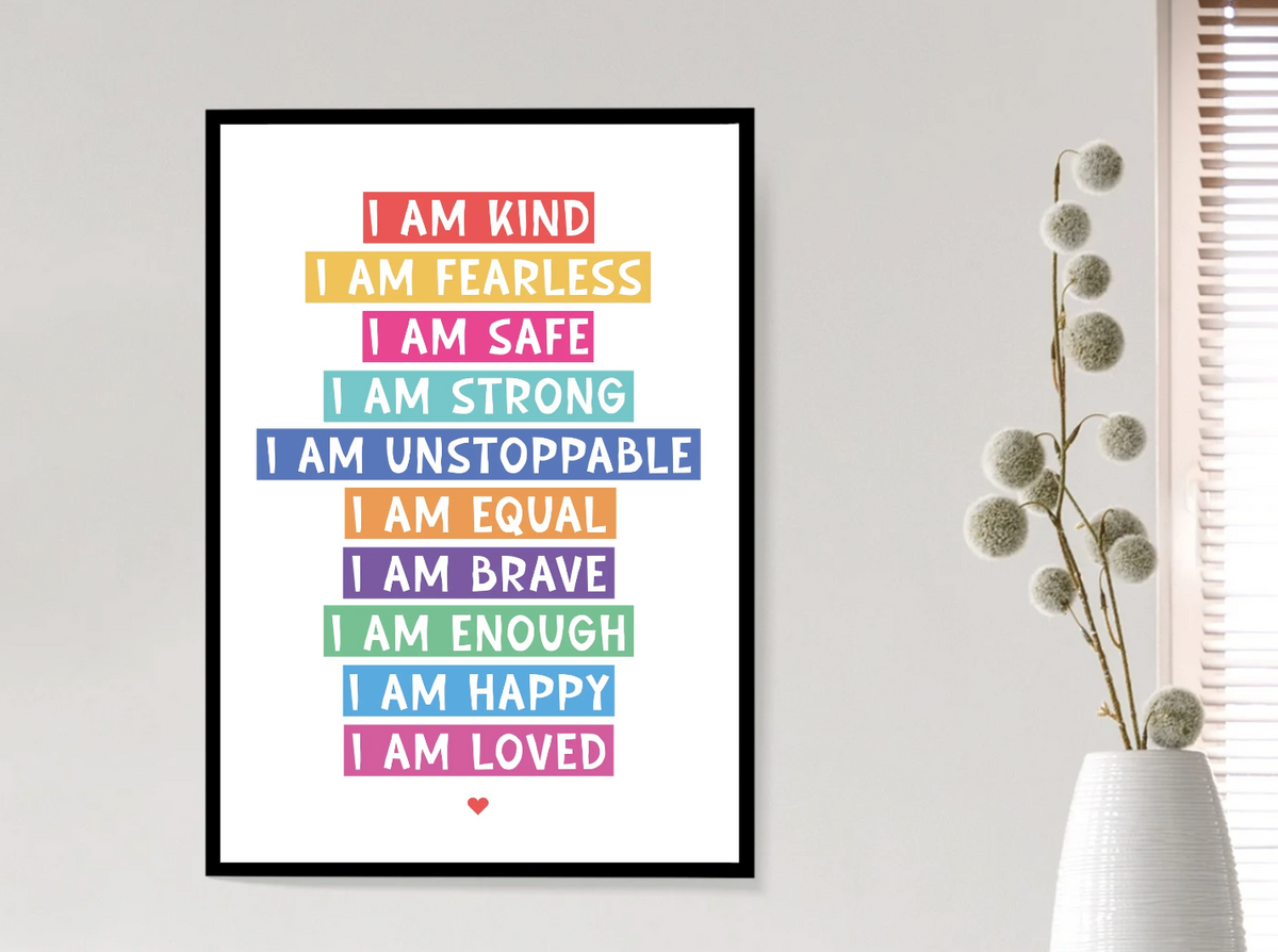 I Am Affirmation Colour print with rainbow-coloured I am kind, fearless and strong lines, framed beside a vase