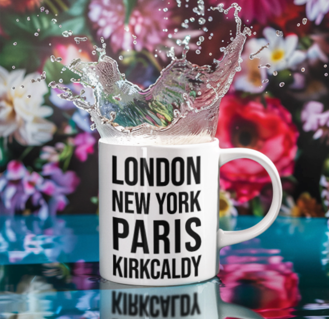 Kirkcaldy Mug with London New York Paris Kirkcaldy text, splashing with liquid in front of colourful flowers
