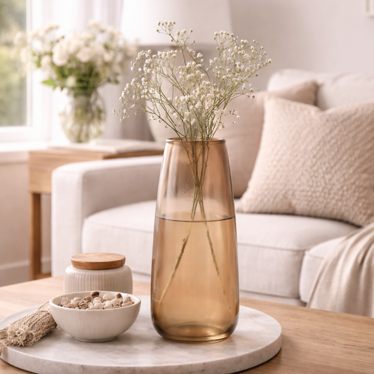 Neutral Glass Vase in smoky amber glass holding dried grasses, on a round table in a cream living room