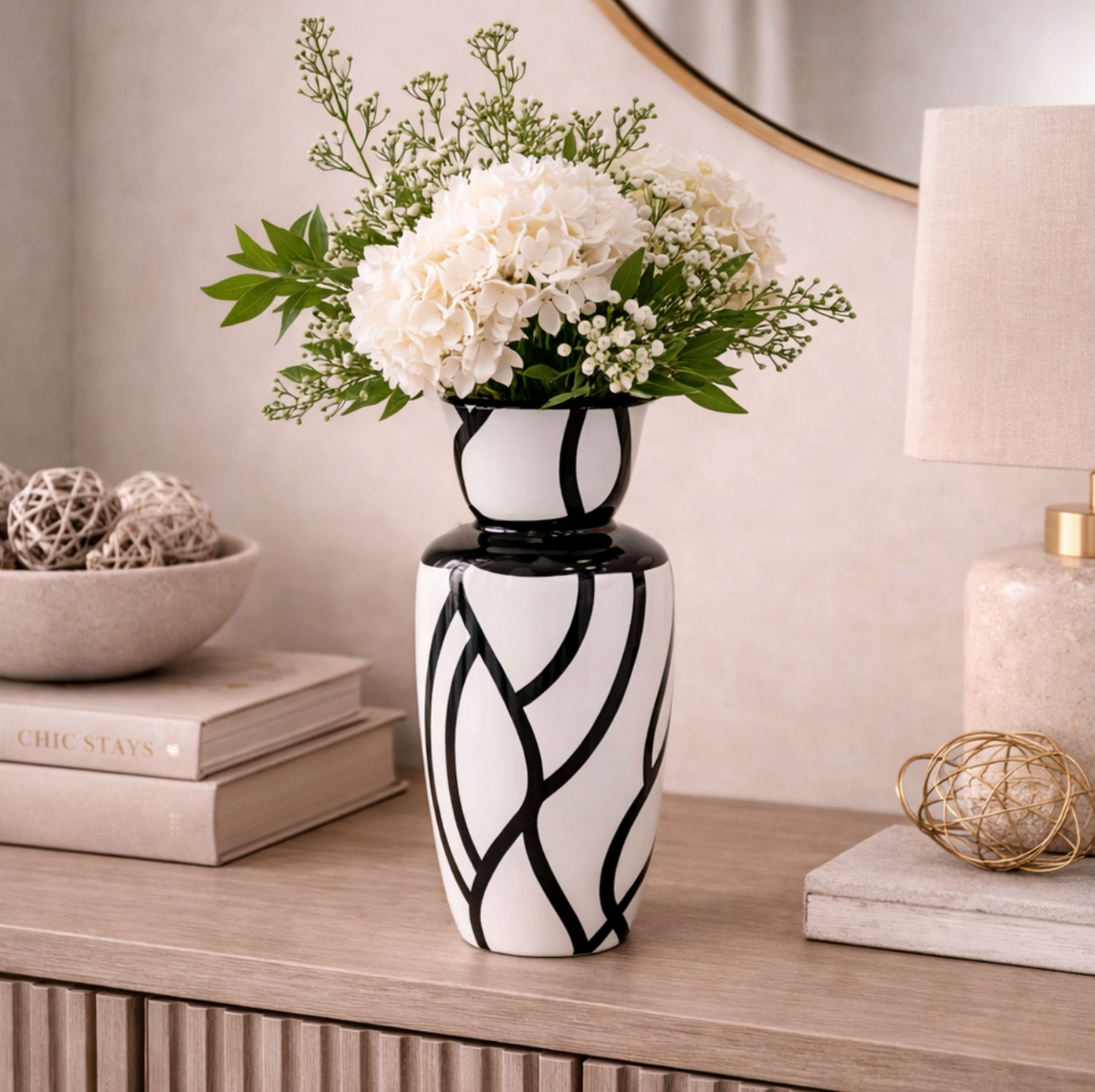 Obsidian Flow Vase, white with black swirling lines, holding white flowers on a sideboard