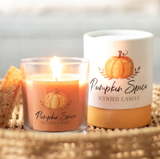 Pumpkin Spice Autumn Candle lit in a glass jar beside its pumpkin-print gift box