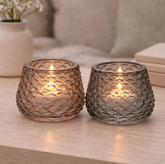 Scalloped Glass Tealight Holder, a pair of smoky textured glass holders with lit tealights on a table