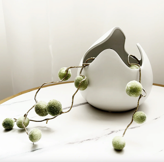 Tula Vase/Styling Piece- White Gloss, a sculptural white egg-shaped vase on a marble surface with greenery
