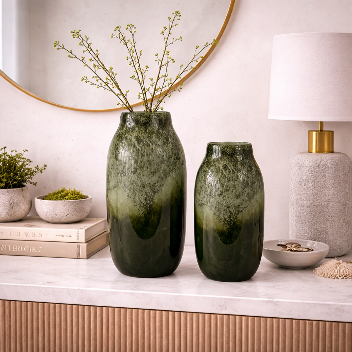 Verde Echo Handmade Glass Vase, Large, shown beside a smaller matching green glass vase on a marble shelf
