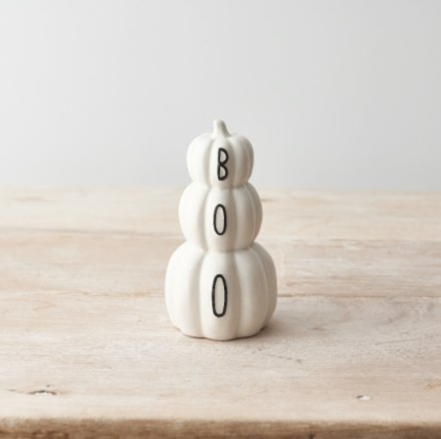 White Pumpkin Stack of three white ceramic pumpkins spelling BOO, on a plain pale surface