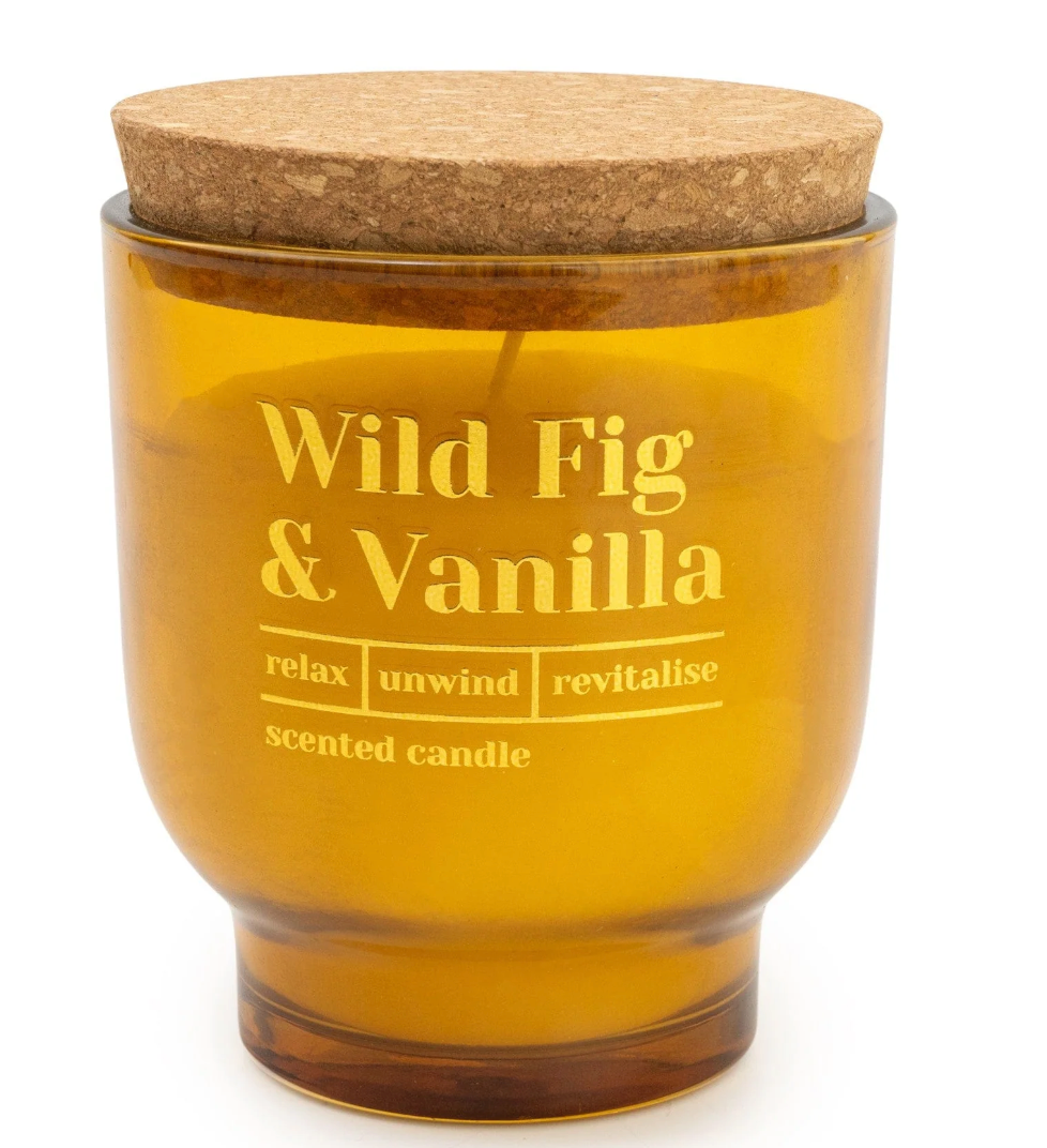 Wild Fig & Vanilla Scented Candle in an amber glass jar with gold lettering and a cork lid, on white